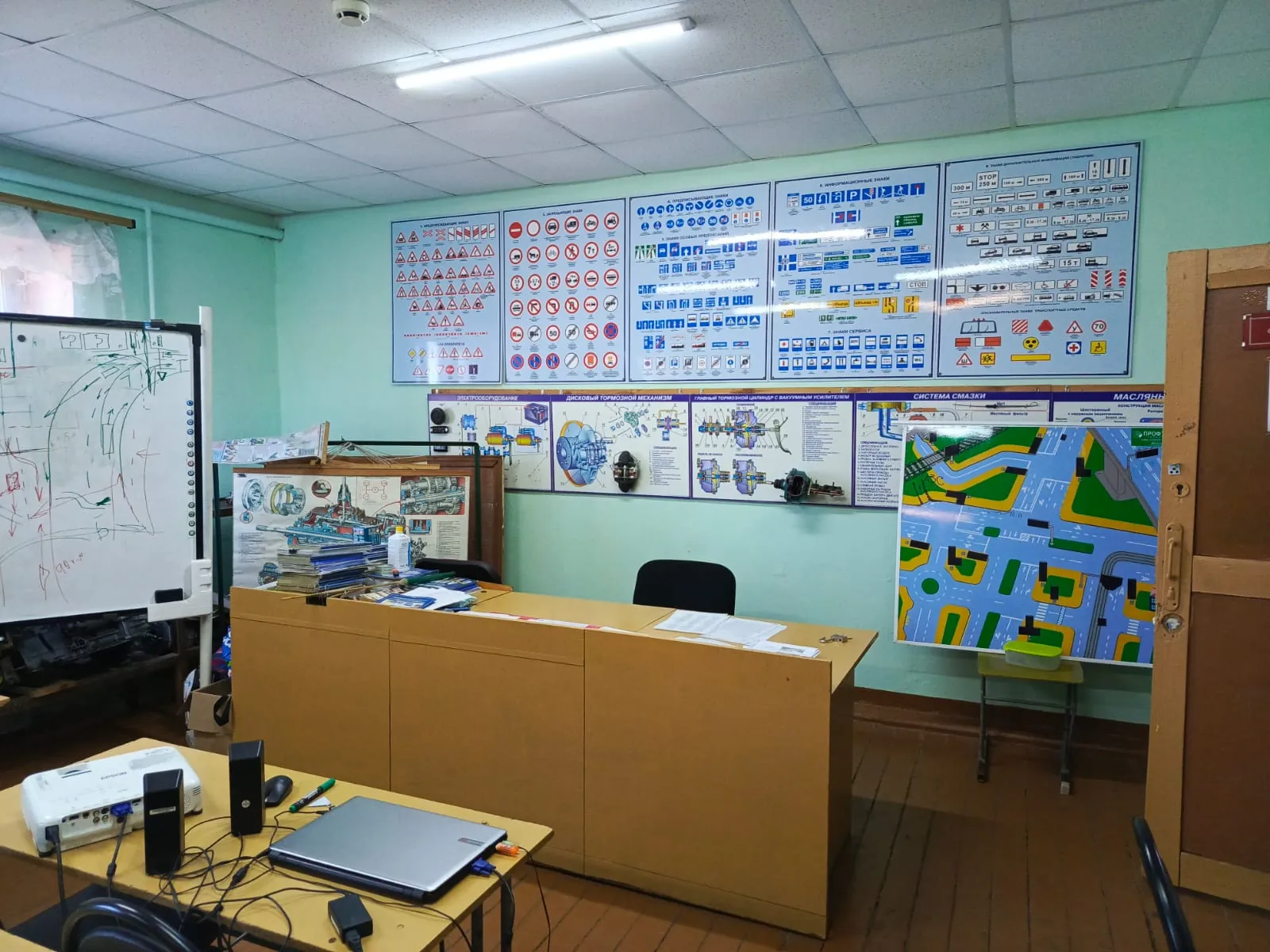 Учебный класс с доской, столом преподавателя, проектором и плакатами по ПДД