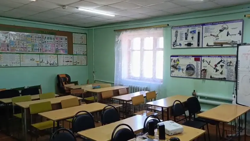Учебный класс: парты в несколько рядов, плакаты по устройству автомобиля на стенах